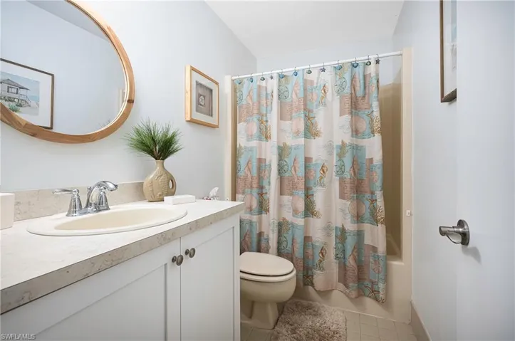Full bathroom with vanity, shower / tub combo, and light tile patterned floors