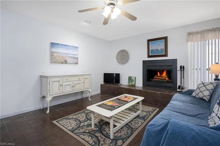 Living room with a tile fireplace and a ceiling fan