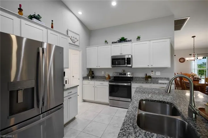 Kitchen with new stainless steel appliances, granite countertops, and lofted ceiling
