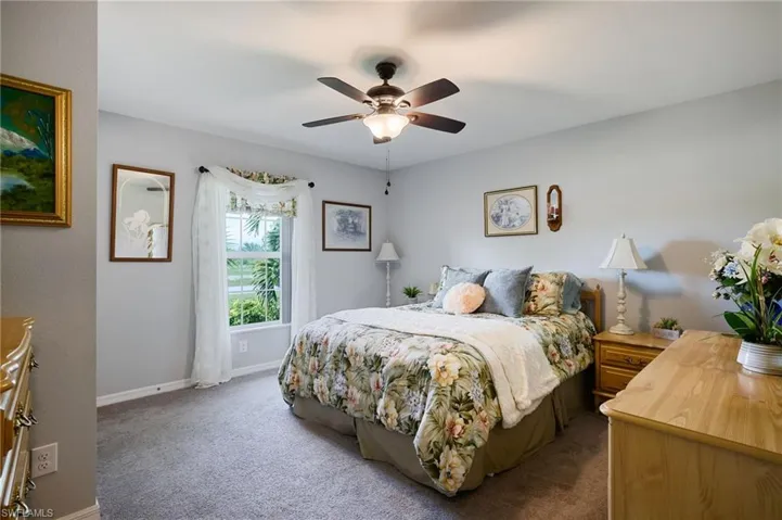 2nd bedroom with light colored carpet, closet, and ceiling fan