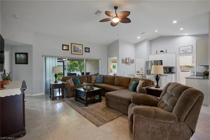 Living area with ceiling fan, high vaulted ceiling, recessed lighting, and light tile patterned flooring
