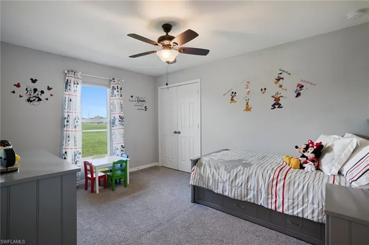 3rd bedroom with light colored carpet, closet, and ceiling fan