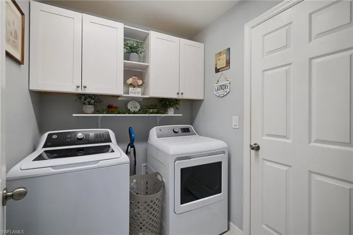 Laundry room featuring washer and dryer and new cabinets