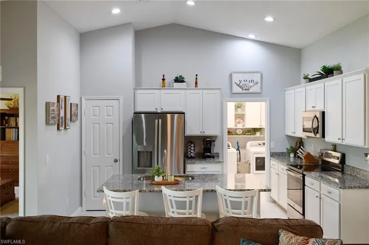 Kitchen with new stainless steel appliances, granite countertops, pantry, and lofted ceiling