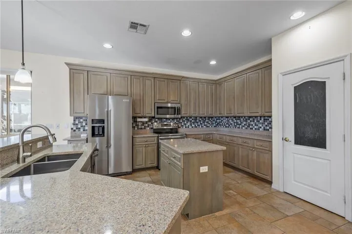 Stainless and quartz kitchen with designer backsplash and oversized pantry