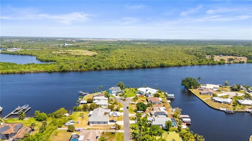 Aerial view of residential area with a heavily wooded area and a nearby body of water