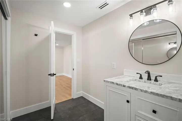 Bathroom with tile patterned floors, visible vents, baseboards, vanity, and recessed lighting