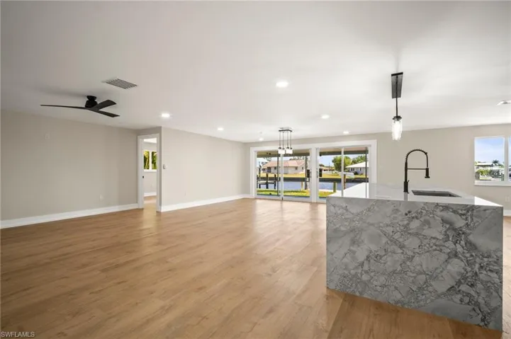 Kitchen featuring a sink, light stone counters, visible vents, recessed lighting, and pendant lighting