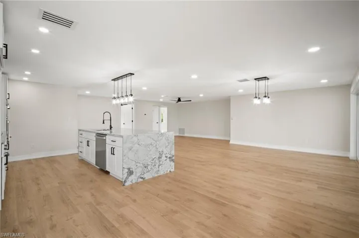 Kitchen featuring a sink, pendant lighting, visible vents, and dishwasher