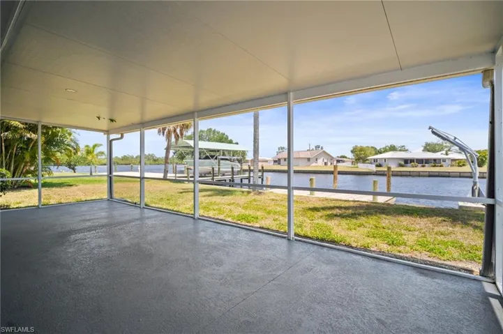 Unfurnished sunroom featuring a water view and a residential view
