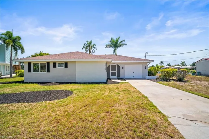 Ranch-style house with concrete driveway, an attached garage, and a front yard