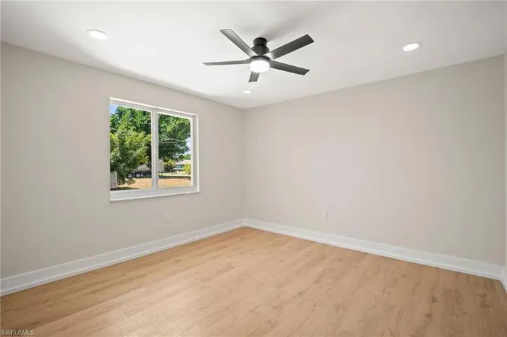 Spare room with light wood-style floors, baseboards, a ceiling fan, and recessed lighting
