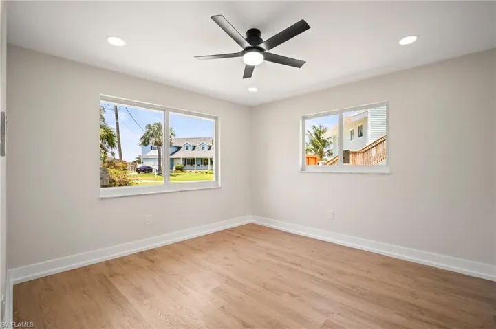 Spare room with light wood finished floors, baseboards, and plenty of natural light