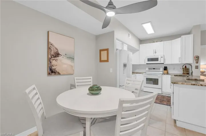 Tiled dining area with ceiling fan and sink