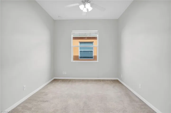Carpeted spare room with ceiling fan
