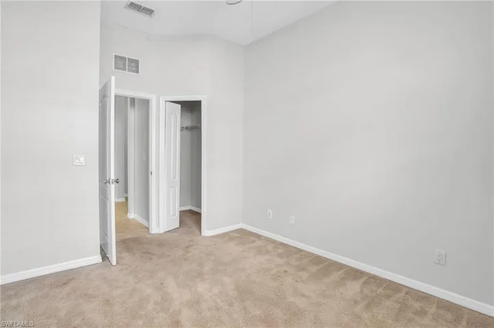 Unfurnished bedroom with light carpet and a closet