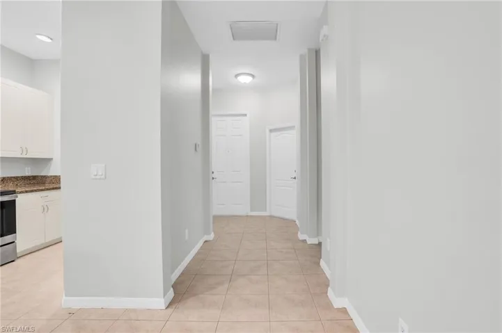 Corridor with light tile patterned flooring