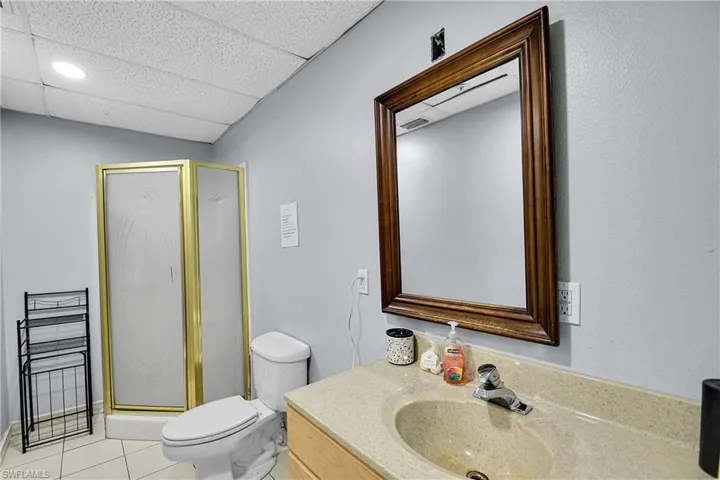 Bathroom featuring a corner shower with a gold-toned frame and frosted glass panels