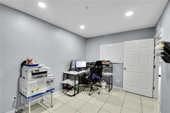 Neutral-toned room with recessed lighting and light-colored tile flooring