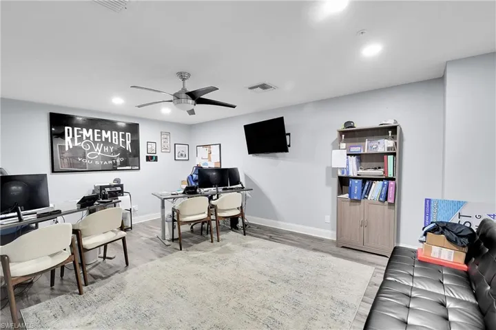 Spacious room featuring wood-finish flooring and light-toned walls