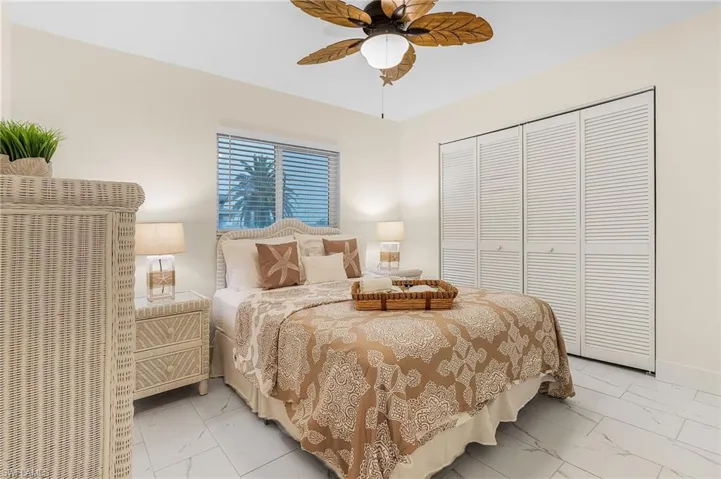 Bedroom with ceiling fan, a closet, and light tile flooring