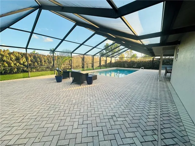 View of swimming pool featuring a patio and glass enclosure