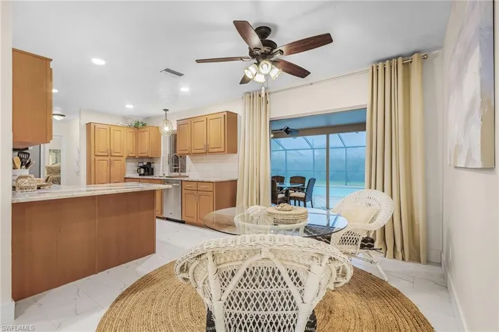 Kitchen featuring ceiling fan, dishwasher, decorative light fixtures, backsplash, and light tile floors