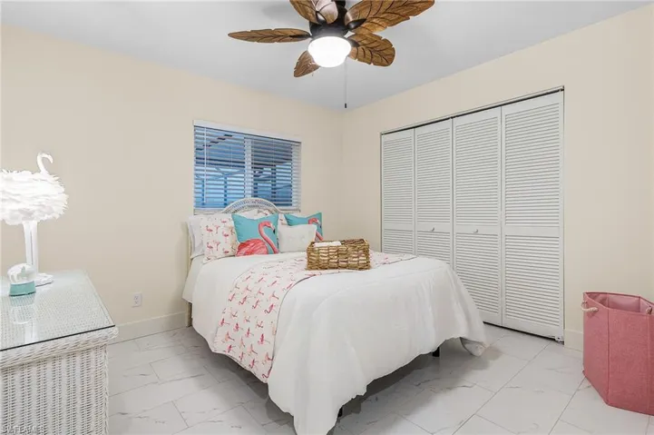 Tiled bedroom with a closet and ceiling fan