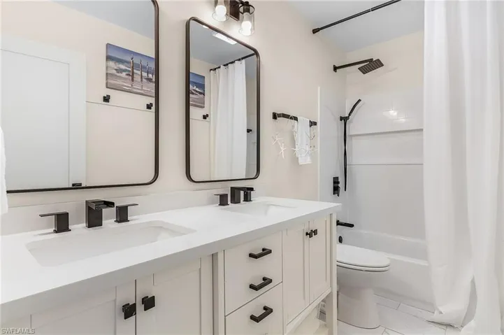 Full bathroom featuring toilet, tile flooring, shower / tub combo, and double sink vanity