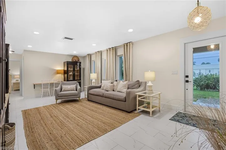 Living room with a wealth of natural light and light tile floors