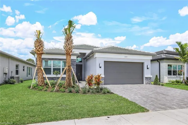 View of front facade featuring a front yard, a garage, and central AC unit