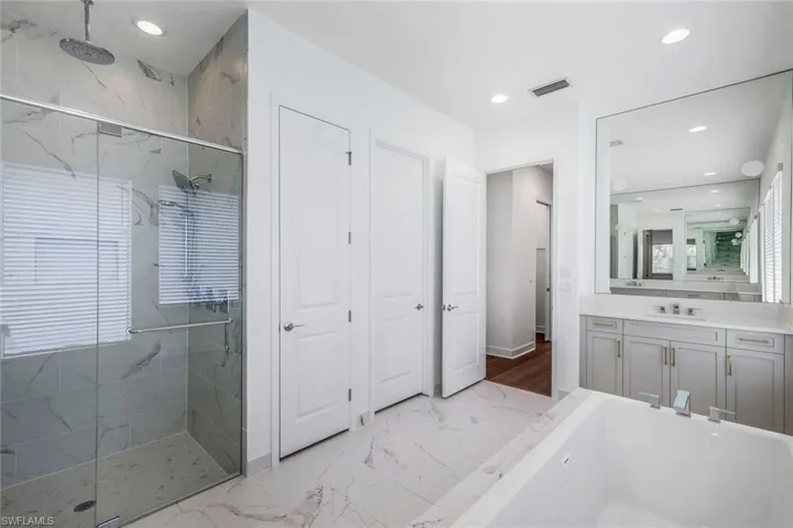 Bathroom featuring tile floors, separate shower and tub, and oversized vanity