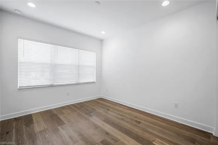 Spare room with dark wood-type flooring