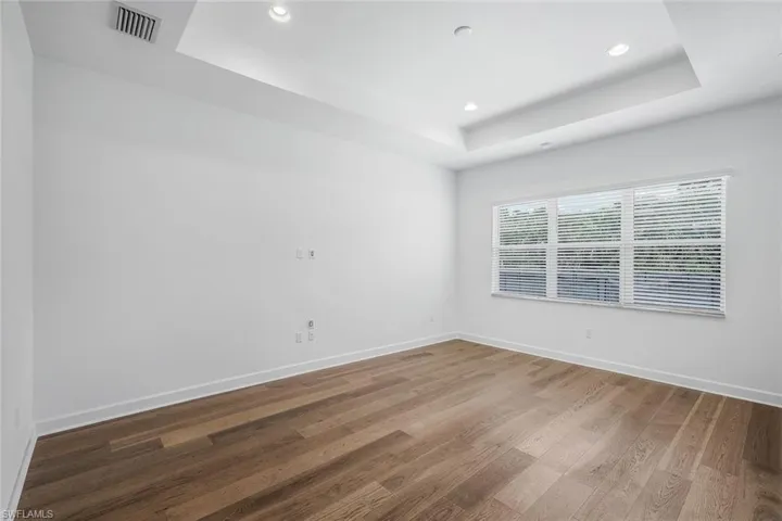 Spare room featuring hardwood / wood-style floors and a raised ceiling