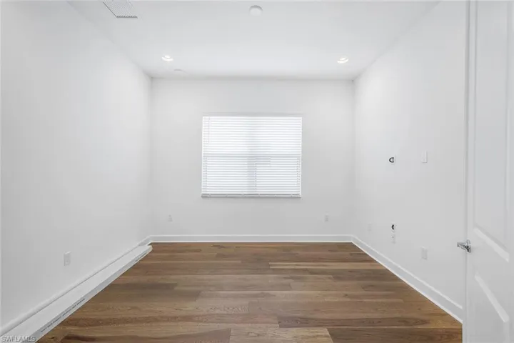 Empty room featuring dark hardwood / wood-style floors