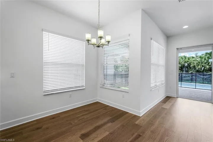Unfurnished dining area featuring a chandelier and hardwood / wood-style flooring