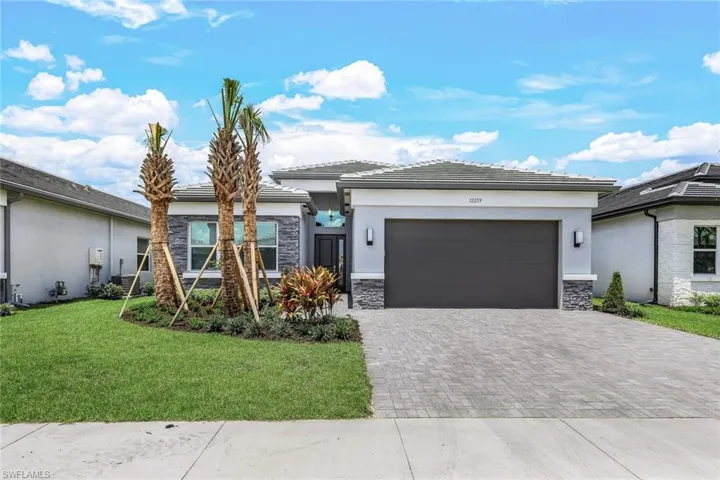 View of front of house featuring a front yard and a garage