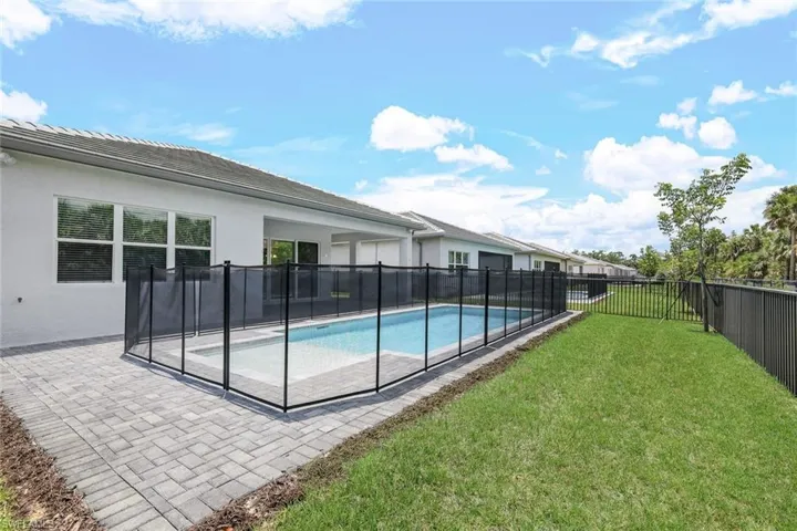 View of pool with a patio area and a lawn
