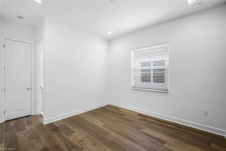 Unfurnished room with dark wood-type flooring