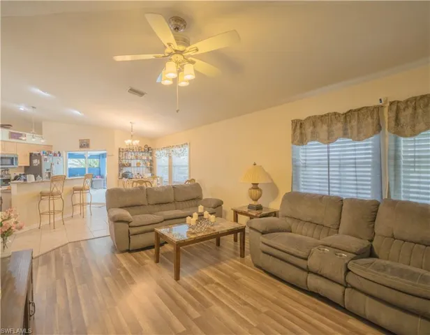 Living room w/dark vinyl flooring & ceiling fan