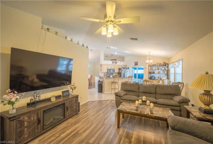 Living room w/dark vinyl flooring & ceiling fan