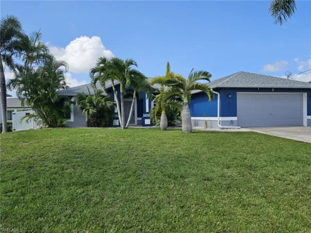 Ranch-style home with a 2-car garage, lush landscaping & inground pool