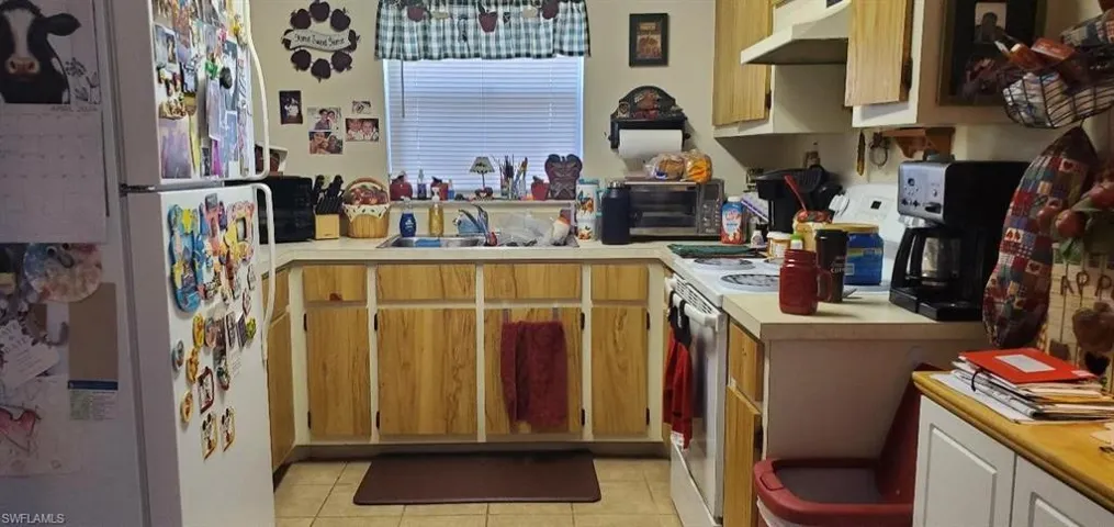 1021 Kitchen featuring sink, white appliances, and light tile floors