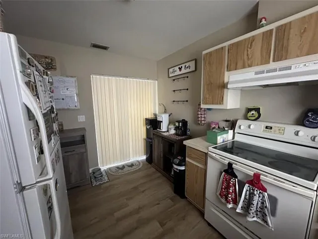 1023 Kitchen with dark hardwood / wood-style floors and white appliances