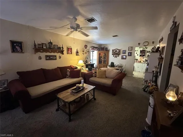 1021 Living room featuring carpet and ceiling fan