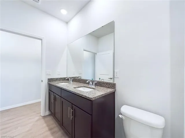 Bathroom with vanity, toilet, and hardwood / wood-style floors
