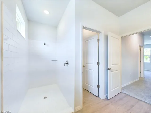 Bathroom featuring hardwood / wood-style floors and a tile shower