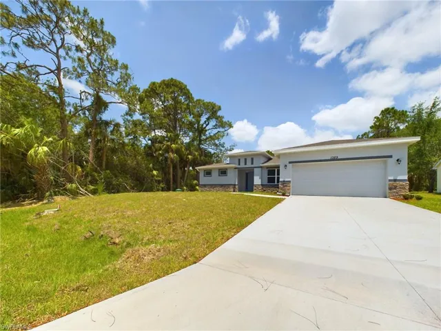 View of front of home with a garage and a front lawn