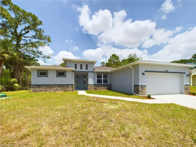 View of front facade featuring a garage and a front yard