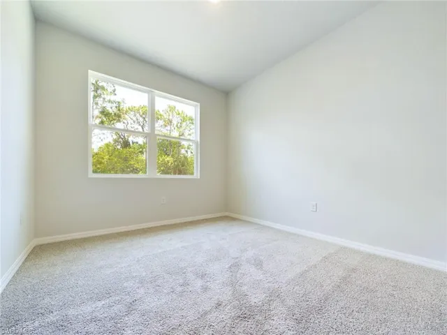 Unfurnished room with lofted ceiling and carpet floors
